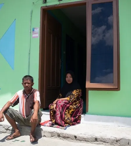 Tasrudin und seine Frau vor seinem fertiggestellten Haus